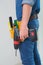 Side view mid section of a handyman with drill and toolbelt