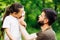 Side view of middle-aged bearded careful man father wiping daughters nose with white handkerchief, walking in forest.