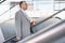 Side view of middle aged businessman with coffee cup walking up stairs in railroad station