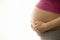 Side View Midsection Of Pregnant Woman With Hands Holding Tummy