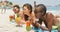 Side view of mixed-race female friends drinking cocktail drinks on the beach 4k