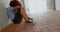 Side view of mixed-race schoolgirl sitting alone on the floor in corridor at school 4k