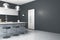 Side view of modern kitchen interior with island, stools, decorative lamps and mock up place on dark grey wall.