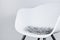 Side view of a modern white plastic chair with a seat cushion made of grey artificial long fur, use as design background for