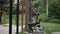 Side view motivated African American young man in wheelchair stretching to sports equipment in summer park training