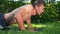 Side view motivated sportsman doing push-ups on exercise mat on sunny summer backyard. Medium shot portrait of muscular