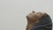 Side view of natural female face looking above close up on white sky background. Macro shot of young woman enjoying