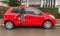Side view of new luxury red small Toyota car destroyed by accident rear door smashed - rainy day