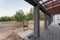 Side view of an open veranda in front of a modern forest cottage. Pine young forest under the sunset rays in the