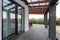 Side view of an open veranda in front of a modern forest cottage. Pine young forest under the sunset rays in the