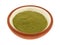 Side view of organic powdered wheat grass in a small bowl
