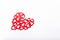Side view patterned big shape of a heart made of wooden cutting red hearts on the white background. Valentine`s day