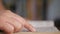 Side view of a person hand touching page when reading a book