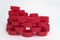 Side view of the pile of red ribbed plastic bottle caps, folded