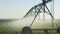 Side view pivot at work in potato field, watering crop for more growth. Center pivot system irrigation. Watering crop in