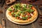 Side view on pizza with minced meat and arugula