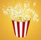 Side view popcorn in striped bucket explosionon yellow backgrou