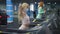 Side view portrait of blond young fit woman in coronavirus face mask running on treadmill as blurred redhead sportswoman