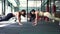 Side view portrait of Caucasian sportswomen gesturing high-five in plank position in gym. Sportive athletic women