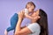 Side view portrait of caucasian woman mother raising baby up, having fun, kissing