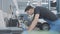 Side view portrait of concentrated Caucasian service man in uniform standing in auto repair shop looking in computer