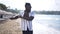 Side view portrait of confident African American sportsman in sunglasses warming up on sandy beach stretching hand