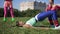 Side view portrait confident sportswoman lying on exercise mat raising hips in slow motion with friends training at