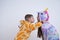 Side view portrait of happy children, boy and girl, brother in giraffe pajamas put his hands on sister`s shoulders