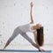 Side view portrait of happy woman doing Extended Triangle pose