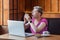 Side view portrait of illness young bussinesswoman with short blonde hair in pink t-shirt and eyeglasses sitting in cafe and