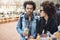 Side-view portrait of serious attractive dark-skinned boyfriend with afro hairstyle walking on food festival with