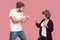 Side view portrait of upset angry couple of friends in casual style standing, disassembly and showing fists to each other, have