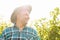 side view of portrait of a winemaker with a hat standing in vineyards