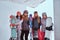 Side view Portrait of a women friends in sports winter clothes holding snowboards and skis posing together near the