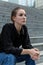 Side View Portrait of Young Caucasian Woman Sitting on Outdoor Steps