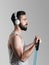 Side view portrait of young male athlete training biceps muscle with resistance band