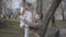 Side view of positive young father talking with cute little daughter in park. Man touching girl`s nose and smiling