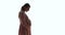 Side view pregnant woman in dress pose on white background