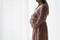 Side view pregnant woman in dress pose on white background