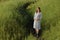 Side view of pregnant woman posing at sunset. Pregnant woman touching gently her tummy.