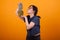 Side view of pretty young woman kissing her delicious ananas in studio over yellow background