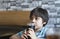 Side view Prtrait of Cute kid sitting on table drinking cold drink in restaurant, Toodler drinking soda or soft drink with straw,