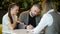 Side view of realtor and young couple sitting at office desk discussing property for sale. Happy couple became a house