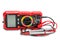 Side view of red portable digital multimeters or multitester with test leads and probes on white background
