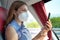 Side view of relaxed woman with KN95 FFP2 face mask using smart phone app. Bus passenger with protective mask traveling texting on