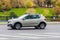 Side view rolling shot with Dacia Sandero Stepway subcompact car. Fast moving beige small hatchback with motion blur effect