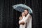 side view of romantic couple in white shirts standing under umbrella under raindrops