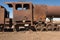 Side view of a rusting steam train as it slowly rots away at the train graveyard just outside of Uyuni, Bolivia