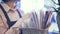 Side view of a saleswoman choosing wrapping paper for a flower bunch, pan shot