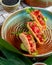 side view of  salmon tacos with red caviar and green onion on a plate